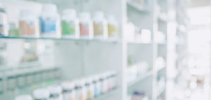 Pharmacy blurred light tone with store drugs shelves interior background.